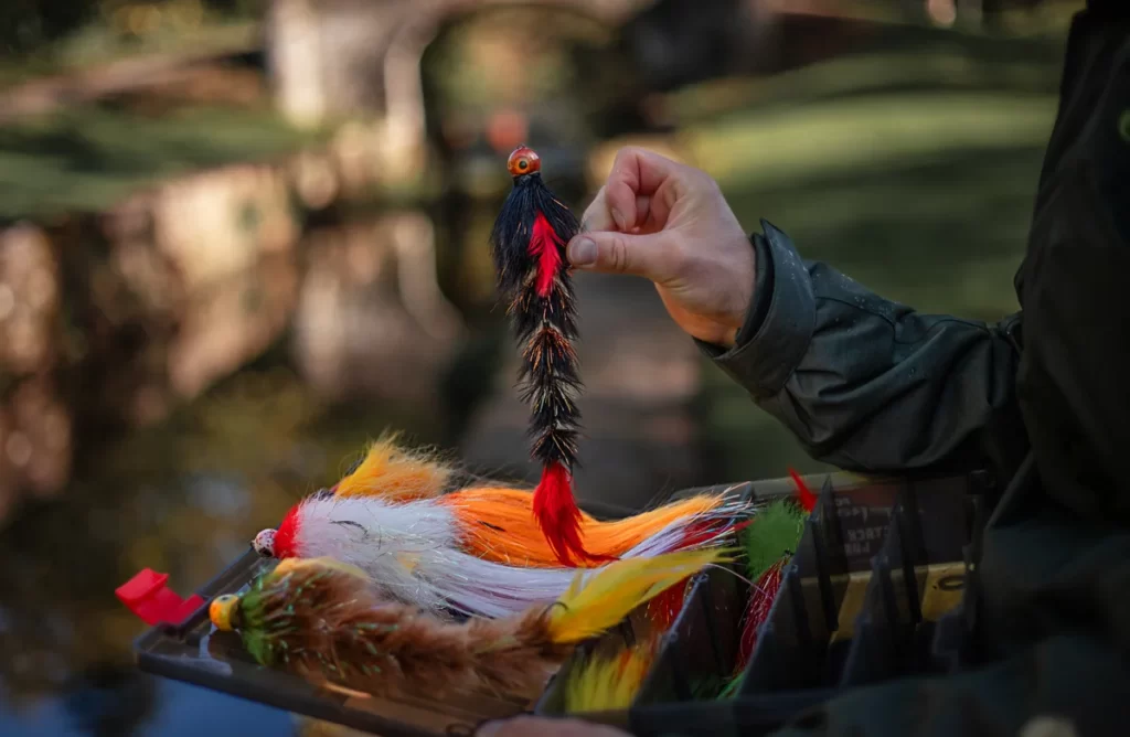 A pike fishing lure designed to resemble a small fish, with vibrant colors and multiple hooks